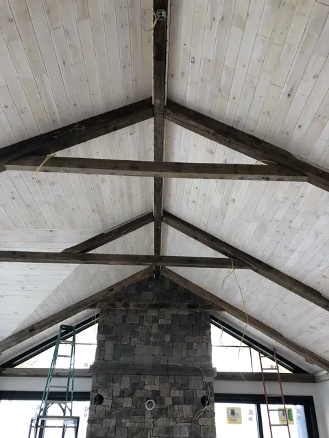 Vaulted ceiling with exposed beams and stone chimney