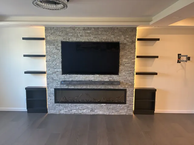 Renovated living room with stacked-stone fireplace wall