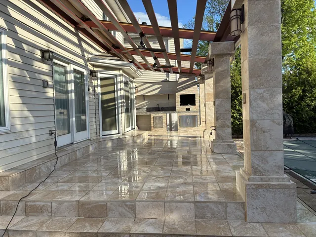 Tiled patio with stone columns and pergola