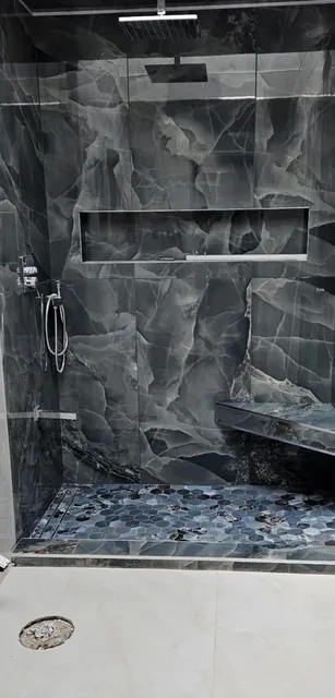 Dark stone-look shower with bench and niche